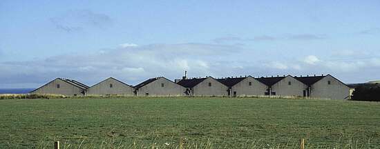 a view over a field onto the warehouses of Glenglassaugh