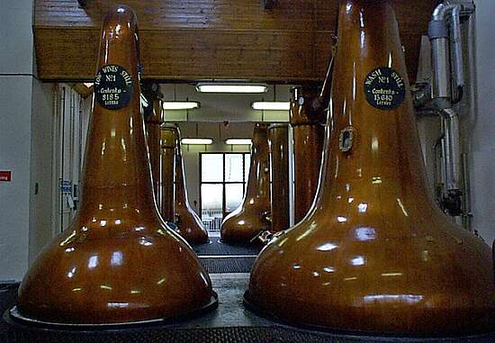 The view of a narrow path between two rows of pot stills.